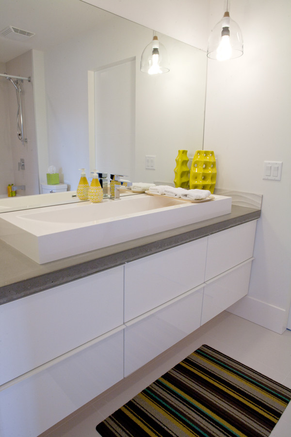 Photo of a medium sized modern family bathroom in Vancouver with a vessel sink, freestanding cabinets, white cabinets, concrete worktops, a freestanding bath, a double shower, a one-piece toilet, white tiles, porcelain tiles, white walls and porcelain flooring.