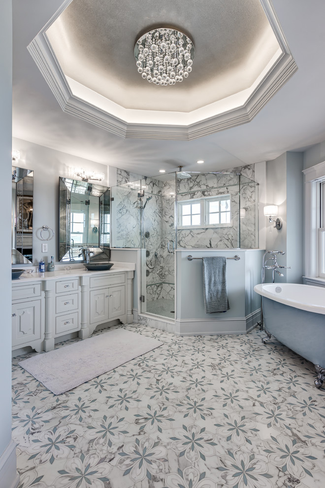Maritim inredning av ett en-suite badrum, med luckor med upphöjd panel, ett badkar med tassar, en hörndusch, vit kakel, marmorkakel, vita väggar, marmorgolv, ett fristående handfat och marmorbänkskiva