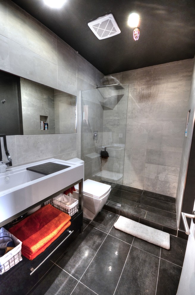 Ejemplo de cuarto de baño minimalista pequeño con lavabo de seno grande, ducha abierta, sanitario de una pieza, baldosas y/o azulejos negros, baldosas y/o azulejos de cemento y aseo y ducha