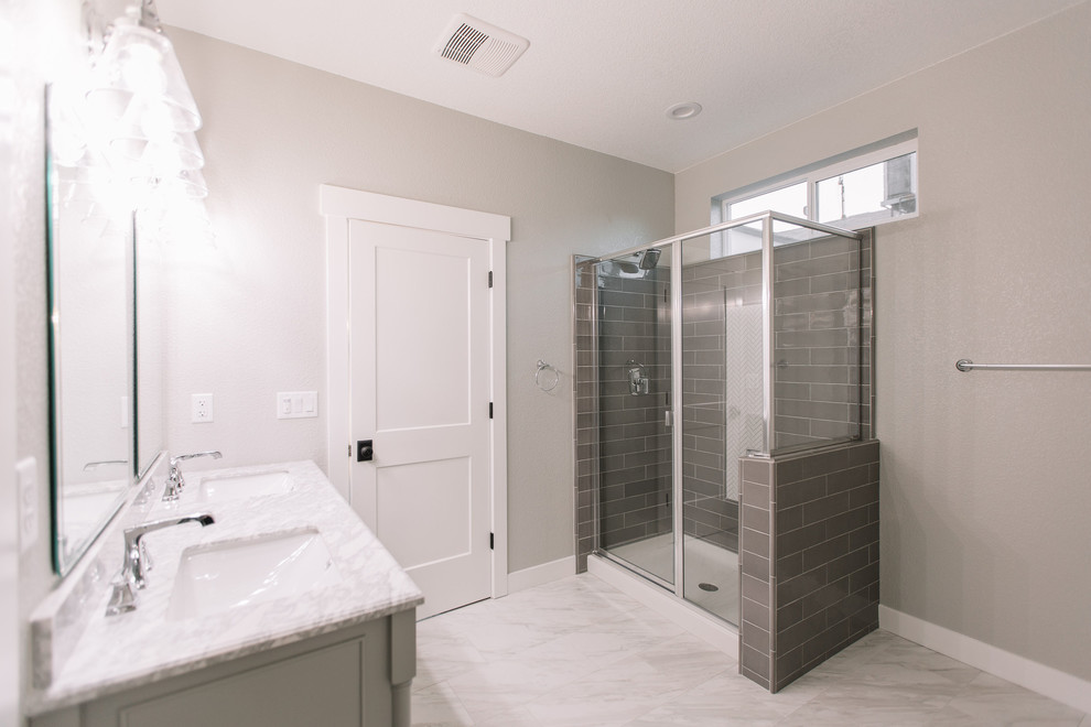 Photo of a medium sized rural ensuite bathroom in Sacramento with raised-panel cabinets, grey cabinets, a built-in bath, a shower/bath combination, a two-piece toilet, grey tiles, ceramic tiles, grey walls, marble flooring, a submerged sink, engineered stone worktops, white floors, a shower curtain and white worktops.