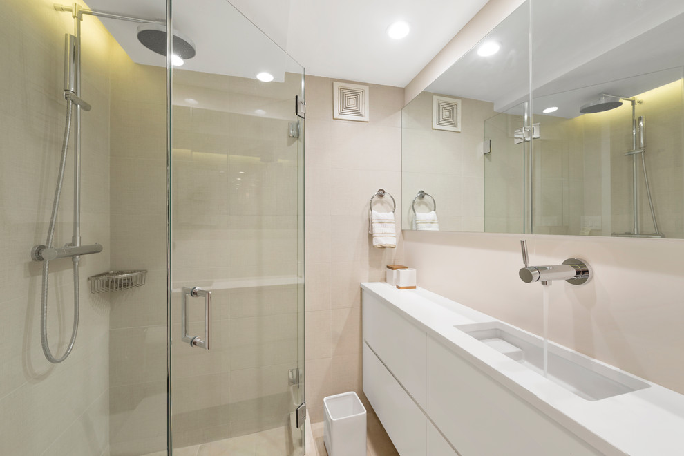Design ideas for a small classic shower room bathroom in New York with flat-panel cabinets, white cabinets, a corner shower, a one-piece toilet, beige tiles, ceramic tiles, ceramic flooring, a built-in sink, quartz worktops, beige floors and a hinged door.