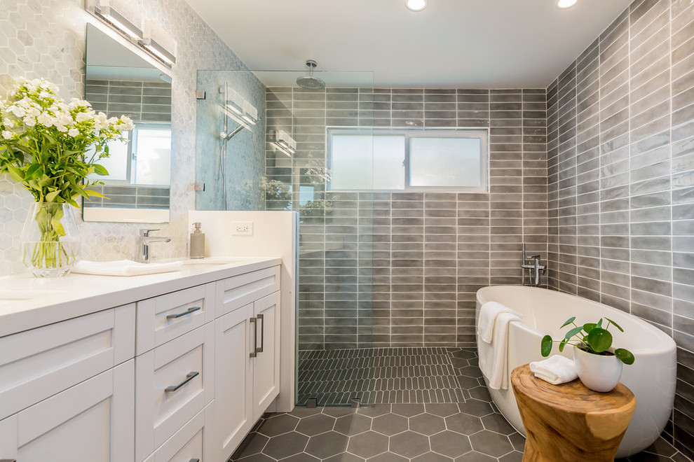 Ejemplo de cuarto de baño principal clásico renovado con armarios estilo shaker, puertas de armario blancas, bañera exenta, baldosas y/o azulejos grises, paredes grises, lavabo bajoencimera, suelo gris y encimeras blancas