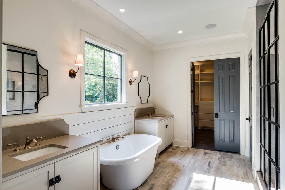 Пример оригинального дизайна: главная ванная комната в стиле кантри с врезной раковиной, фасадами в стиле шейкер, белыми фасадами, отдельно стоящей ванной, душем в нише, белыми стенами и светлым паркетным полом