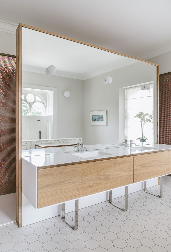 На фото: ванная комната в современном стиле с плоскими фасадами, светлыми деревянными фасадами, плиткой мозаикой, монолитной раковиной, белым полом и белой столешницей