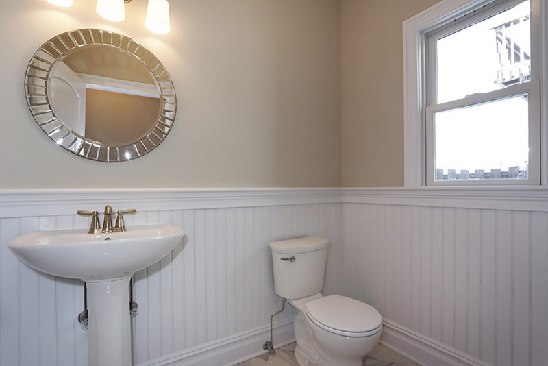 Foto di una grande stanza da bagno con doccia minimalista con WC monopezzo, pareti beige, pavimento con piastrelle in ceramica e lavabo a colonna