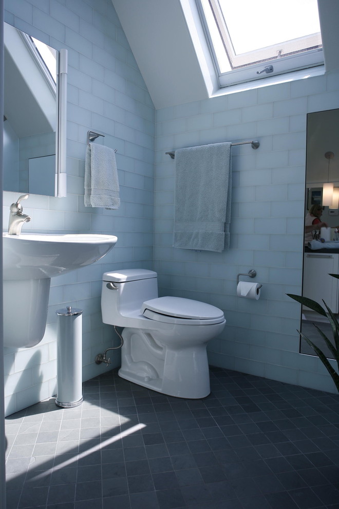 Immagine di una stanza da bagno minimalista con lavabo sospeso e pavimento nero