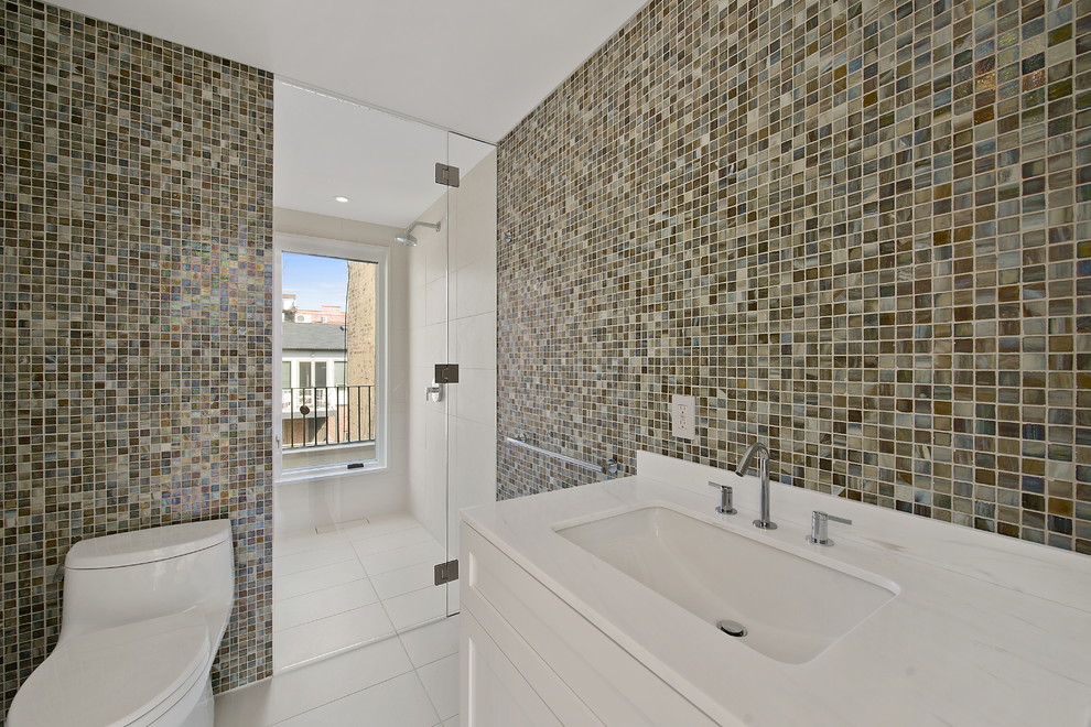 Modernes Badezimmer mit Mosaikfliesen und weißer Waschtischplatte in New York