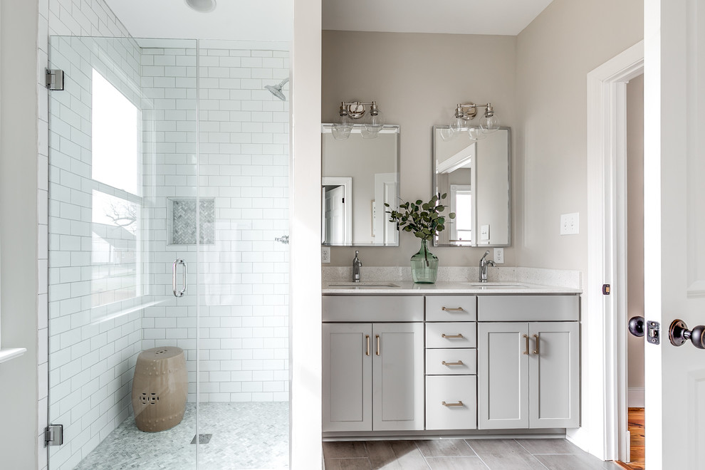 Example of a mid-sized transitional white tile and ceramic tile ceramic tile and gray floor alcove shower design in Richmond with shaker cabinets, gray cabinets, an undermount sink, quartz countertops, white countertops, beige walls and a hinged shower door