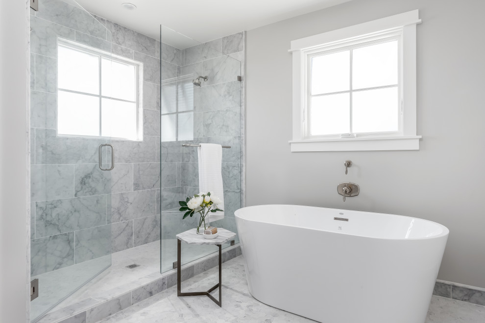 Idee per una stanza da bagno padronale tradizionale di medie dimensioni con vasca freestanding, doccia alcova, pareti grigie, pavimento in marmo, pavimento grigio e porta doccia a battente