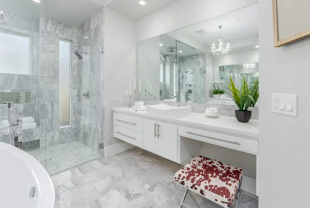 Photo of a medium sized modern ensuite bathroom in Sacramento with flat-panel cabinets, white cabinets, a freestanding bath, a double shower, a one-piece toilet, white tiles, stone tiles, white walls, marble flooring, an integrated sink, limestone worktops, grey floors, an open shower and white worktops.