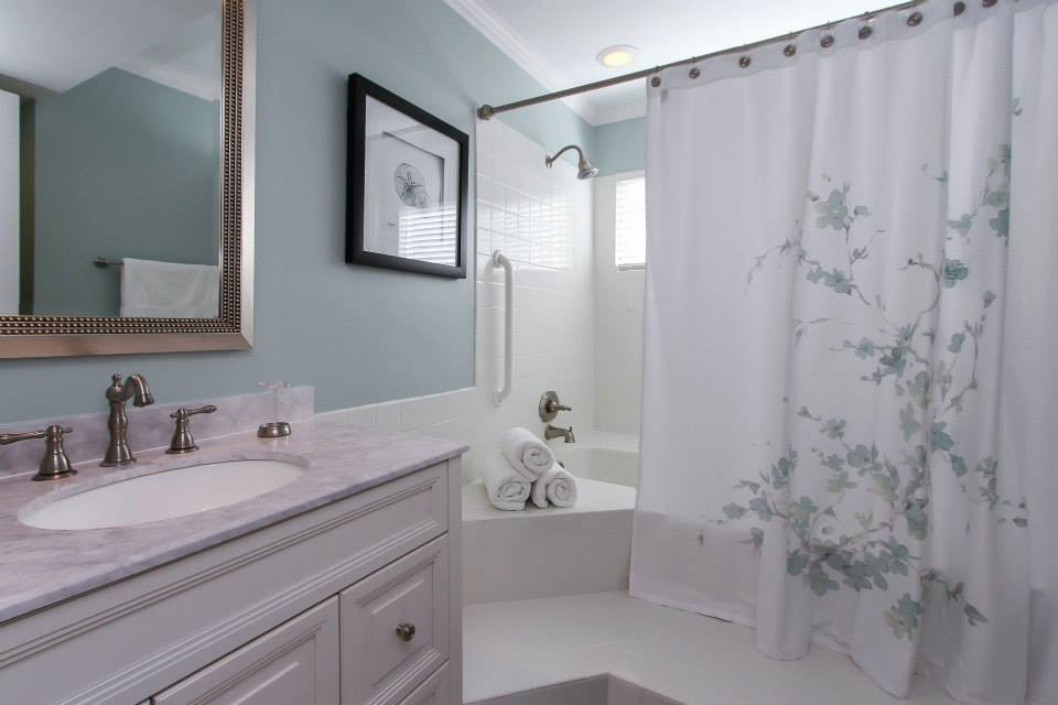 Réalisation d'une salle de bain principale marine de taille moyenne avec un placard avec porte à panneau surélevé, des portes de placard blanches, une baignoire en alcôve, un combiné douche/baignoire, WC séparés, un carrelage blanc, des carreaux de céramique, un mur bleu, un sol en carrelage de céramique, un lavabo encastré, un plan de toilette en marbre, un sol blanc, une cabine de douche avec un rideau, un plan de toilette blanc, meuble simple vasque et meuble-lavabo sur pied.