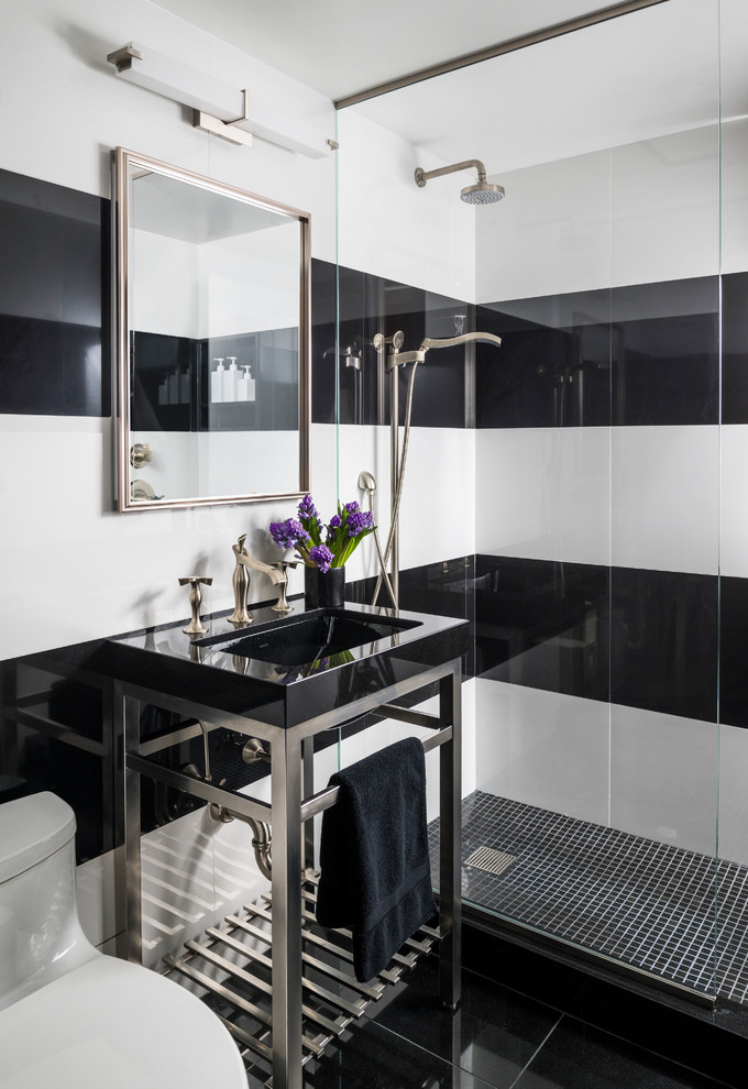 Kleines Modernes Duschbad mit schwarz-weißen Fliesen, schwarzer Waschtischplatte, Duschnische, Toilette mit Aufsatzspülkasten, bunten Wänden, Waschtischkonsole und schwarzem Boden in New York