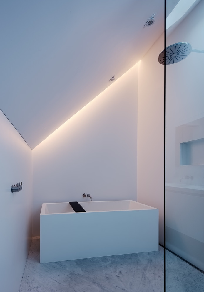 Imagen de cuarto de baño minimalista sin sin inodoro con bañera exenta, paredes blancas, suelo blanco y ducha abierta