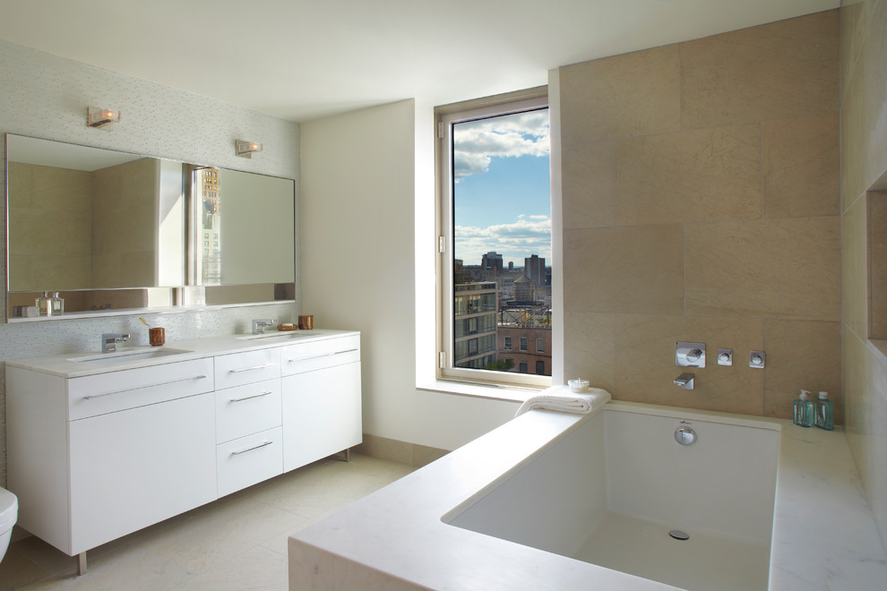 Источник вдохновения для домашнего уюта: ванная комната в современном стиле с врезной раковиной, плоскими фасадами, белыми фасадами, полновстраиваемой ванной и бежевой плиткой