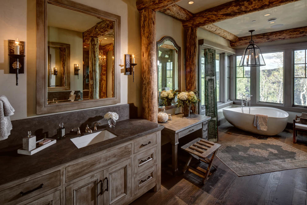 Идея дизайна: большая главная ванная комната в стиле рустика с фасадами цвета дерева среднего тона, отдельно стоящей ванной, бежевыми стенами, врезной раковиной, темным паркетным полом, фасадами с утопленной филенкой, коричневым полом и окном