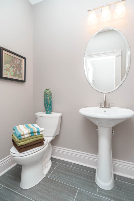 Foto de cuarto de baño clásico renovado de tamaño medio con lavabo con pedestal, sanitario de una pieza, baldosas y/o azulejos grises, baldosas y/o azulejos de cerámica, paredes grises y suelo de baldosas de cerámica
