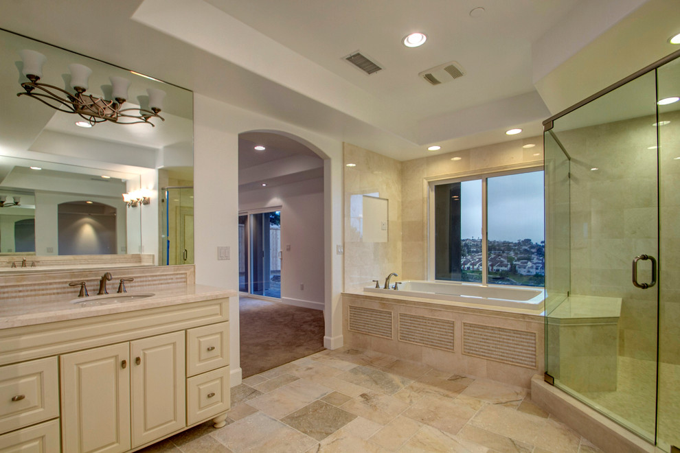 Ejemplo de cuarto de baño contemporáneo con lavabo bajoencimera, puertas de armario blancas, baldosas y/o azulejos beige, baldosas y/o azulejos de piedra, paredes blancas y suelo de travertino