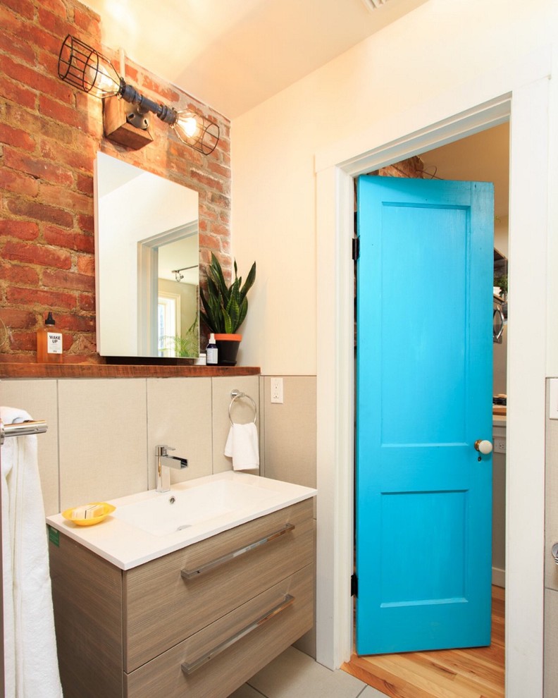 Aménagement d'une salle de bain contemporaine avec un placard à porte plane, des portes de placard beiges, un mur orange et un lavabo posé.