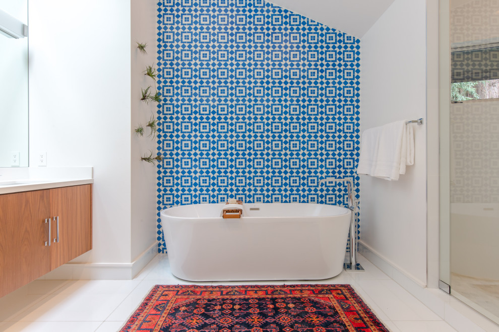 Idée de décoration pour une douche en alcôve principale design en bois brun avec un placard à porte plane, une baignoire indépendante, un carrelage bleu, un mur blanc, un sol blanc, un plan de toilette blanc et meuble-lavabo suspendu.