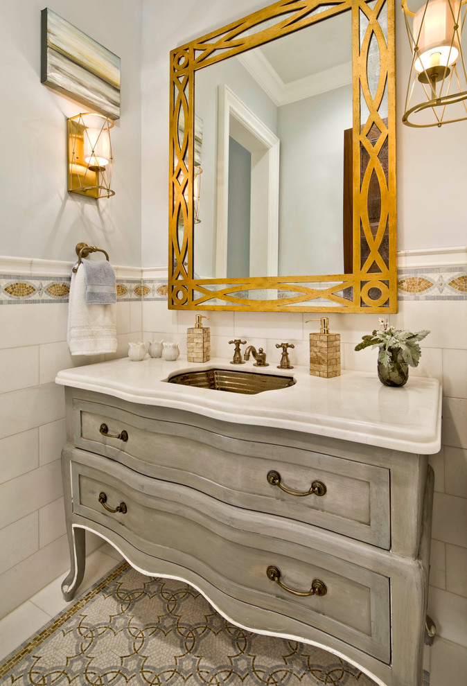 Modelo de cuarto de baño tradicional con lavabo bajoencimera, puertas de armario grises, baldosas y/o azulejos blancos y armarios estilo shaker