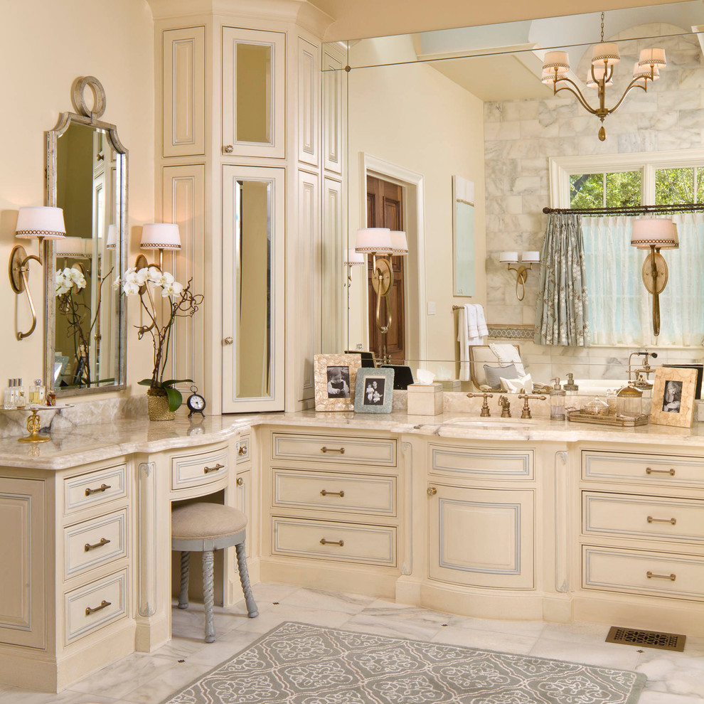 Exemple d'une salle de bain chic avec un lavabo encastré, des portes de placard beiges et un carrelage gris.