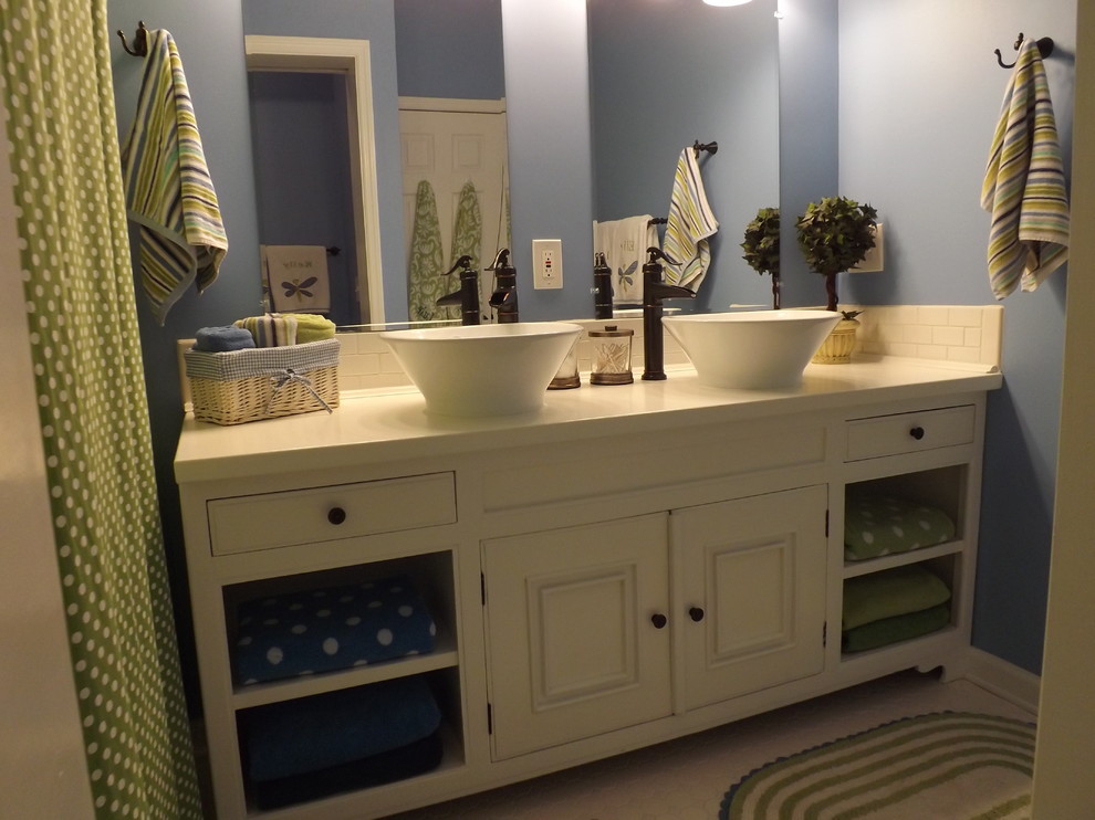 Réalisation d'une petite salle de bain tradition avec une vasque, un plan de toilette en bois, un carrelage blanc, un placard en trompe-l'oeil, des portes de placard blanches, une baignoire indépendante, des carreaux de céramique et un mur bleu.
