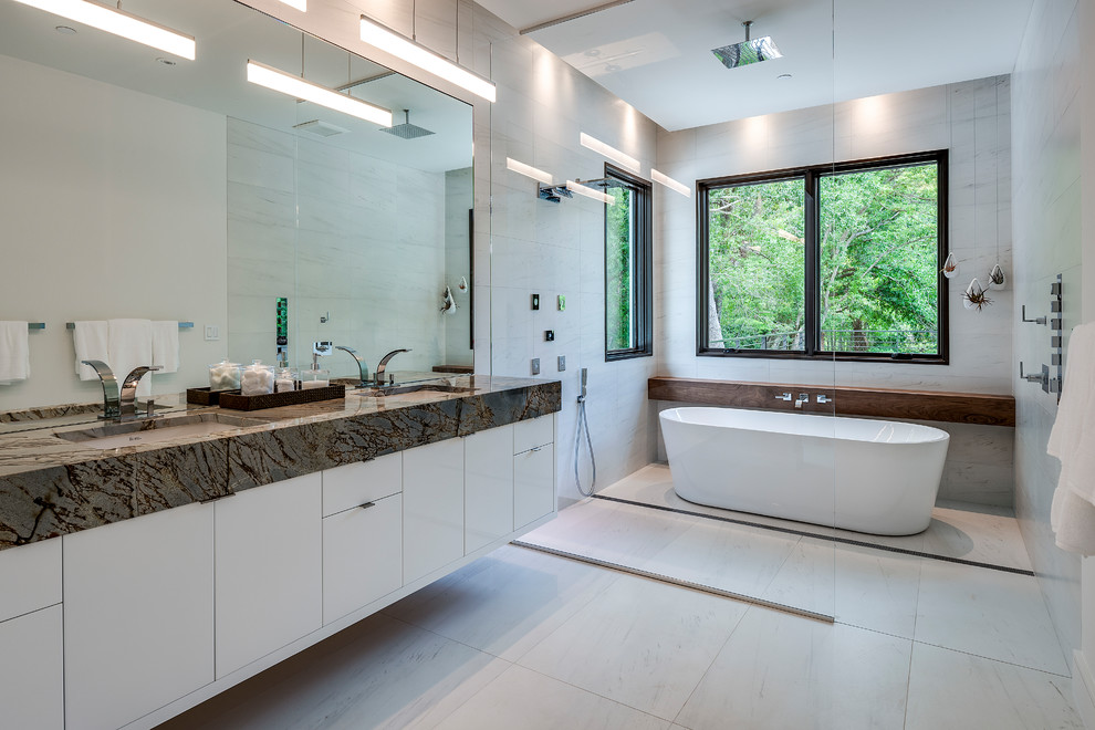 Foto de cuarto de baño principal contemporáneo con armarios con paneles lisos, puertas de armario blancas, bañera exenta, ducha doble, paredes grises, lavabo bajoencimera, suelo gris, ducha abierta y encimeras grises