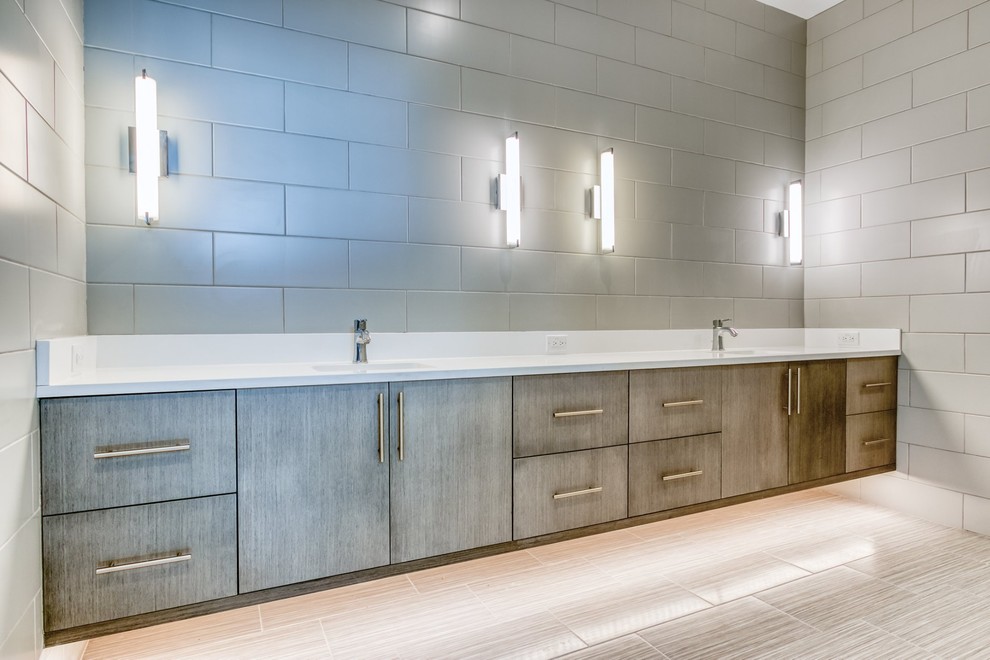 Cette photo montre une grande salle de bain moderne en bois clair avec une baignoire indépendante, un carrelage gris, des carreaux de céramique, un plan de toilette en quartz et un plan de toilette blanc.