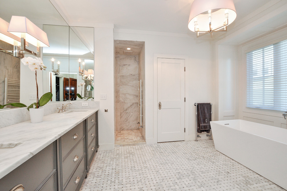 На фото: главная ванная комната в классическом стиле с фасадами с утопленной филенкой, серыми фасадами, отдельно стоящей ванной, угловым душем, белыми стенами, полом из мозаичной плитки, врезной раковиной, серым полом, открытым душем и белой столешницей