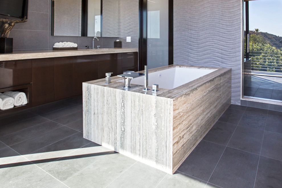 Bathroom - large modern master gray tile and ceramic tile porcelain tile, beige floor, single-sink and vaulted ceiling bathroom idea in Los Angeles with flat-panel cabinets, brown cabinets, limestone countertops, beige countertops and a built-in vanity