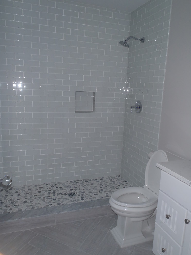 На фото: ванная комната среднего размера в стиле неоклассика (современная классика) с фасадами с филенкой типа жалюзи, белыми фасадами, душем в нише, раздельным унитазом, серой плиткой, стеклянной плиткой, серыми стенами, полом из керамогранита, душевой кабиной, серым полом и белой столешницей