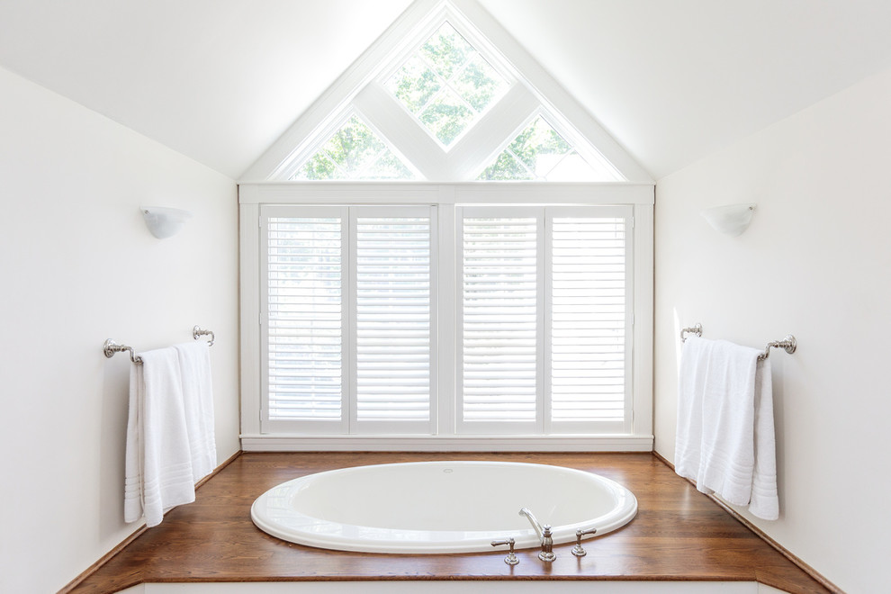 Bild på ett stort vintage vit vitt en-suite badrum, med vita skåp, ett platsbyggt badkar, en dusch i en alkov, vita väggar, mörkt trägolv, ett nedsänkt handfat, bänkskiva i akrylsten och dusch med gångjärnsdörr