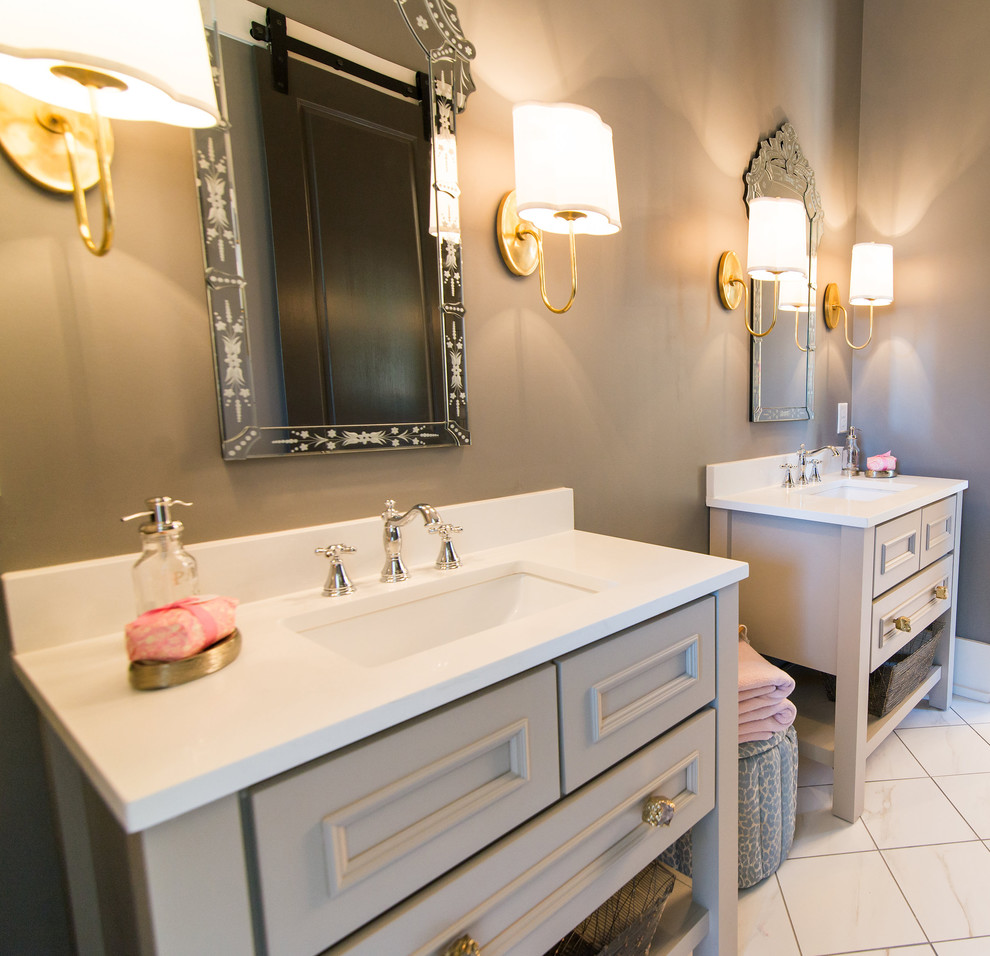 Modelo de cuarto de baño principal clásico renovado con armarios tipo mueble, puertas de armario grises, baldosas y/o azulejos blancos, paredes grises, suelo de mármol y lavabo bajoencimera
