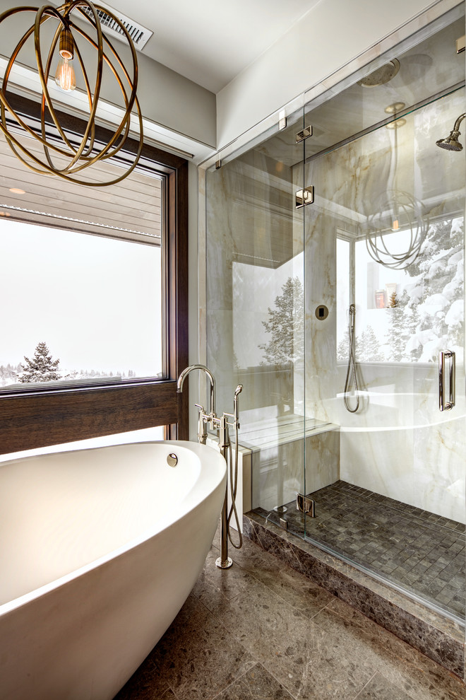 Свежая идея для дизайна: большая главная ванная комната в стиле модернизм с отдельно стоящей ванной, душем в нише, раздельным унитазом, бежевой плиткой, белой плиткой, плиткой из листового камня, серыми стенами, полом из керамической плитки, коричневым полом и душем с распашными дверями - отличное фото интерьера