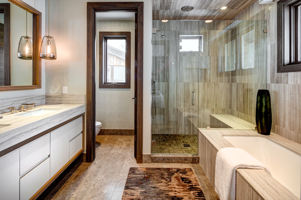 Inredning av ett modernt stort en-suite badrum, med släta luckor, vita skåp, ett undermonterat badkar, en dusch i en alkov, beige väggar, ett undermonterad handfat, beiget golv, dusch med gångjärnsdörr, beige kakel, brun kakel, porslinskakel, klinkergolv i porslin och marmorbänkskiva