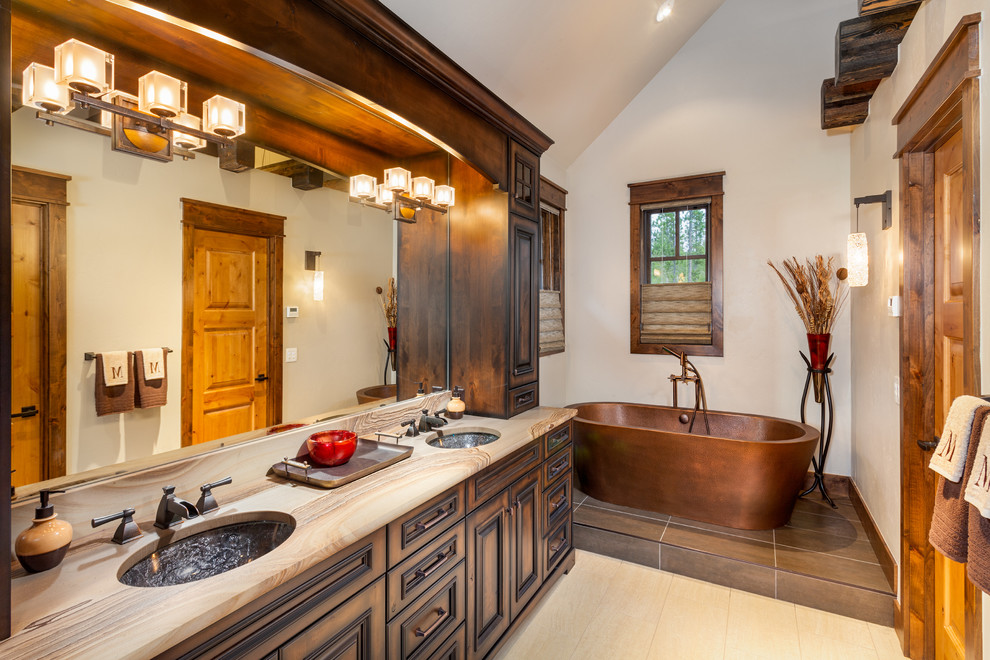 Diseño de cuarto de baño rústico con lavabo bajoencimera, armarios con paneles con relieve, puertas de armario de madera en tonos medios, bañera exenta y paredes blancas