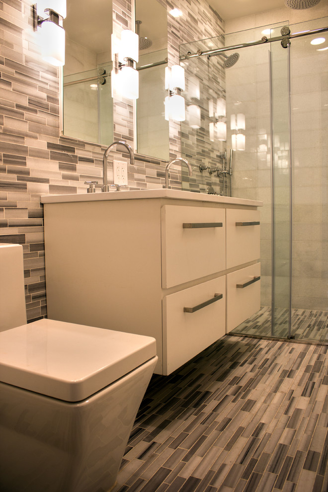 На фото: маленькая ванная комната в стиле модернизм с плоскими фасадами, белыми фасадами, душем без бортиков, серой плиткой, серыми стенами, полом из мозаичной плитки, душевой кабиной и накладной раковиной для на участке и в саду с