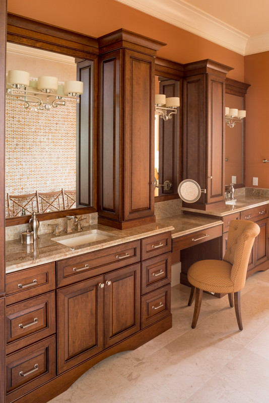 Inspiration for a large classic ensuite bathroom in Atlanta with raised-panel cabinets, medium wood cabinets, a freestanding bath, beige tiles, glass sheet walls, orange walls, travertine flooring, a submerged sink and granite worktops.