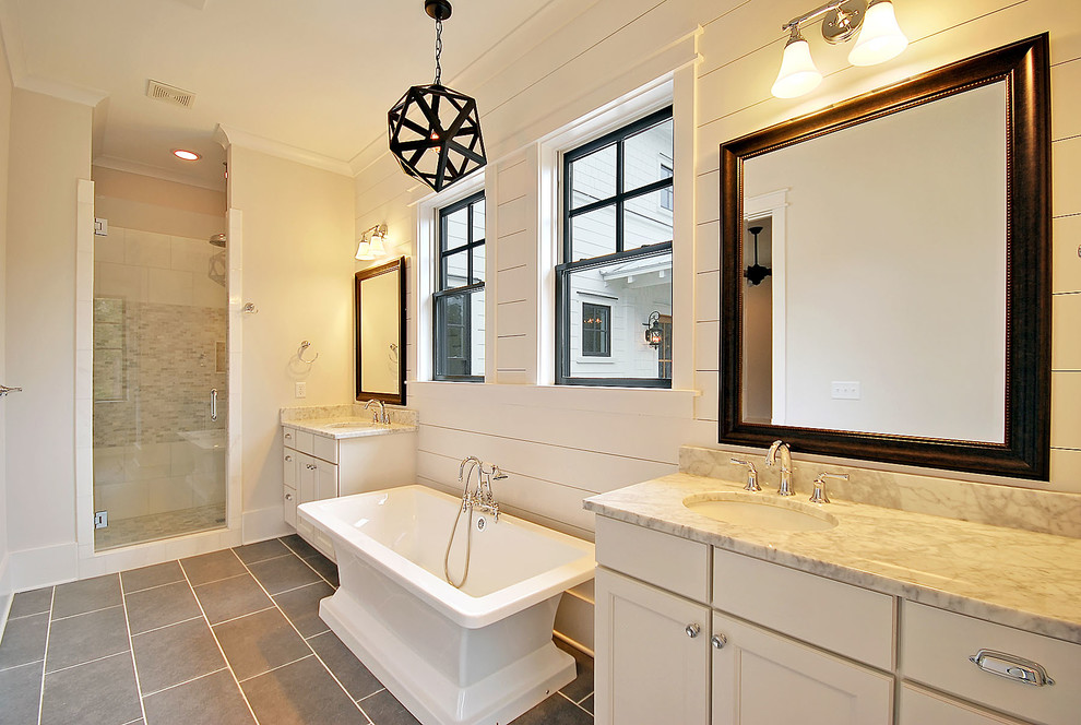 На фото: ванная комната среднего размера в классическом стиле с фасадами с утопленной филенкой, белыми фасадами, отдельно стоящей ванной, душем в нише, серой плиткой, плиткой мозаикой, белыми стенами, полом из керамогранита, душевой кабиной, врезной раковиной, мраморной столешницей, серым полом и душем с распашными дверями