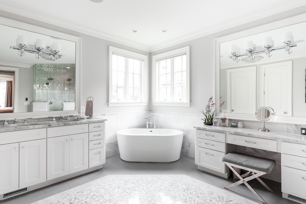 Idee per una grande stanza da bagno padronale classica con ante in stile shaker, ante bianche, vasca freestanding, piastrelle grigie, pareti grigie, lavabo integrato e pavimento grigio