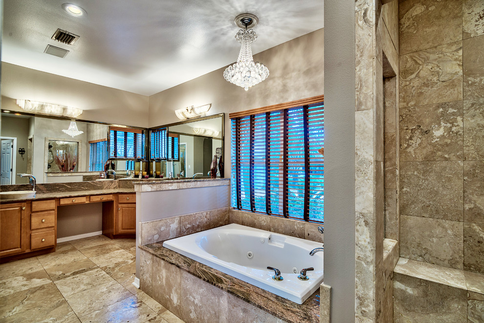 Inspiration for a large mediterranean master multicolored tile and stone tile travertine floor bathroom remodel in Miami with raised-panel cabinets, light wood cabinets, a one-piece toilet, beige walls, a vessel sink and granite countertops