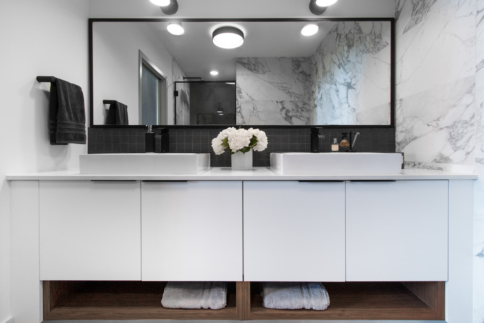 Design ideas for a contemporary bathroom in Miami with flat-panel cabinets, white cabinets, a corner shower, black tiles, white tiles, white walls, a vessel sink, a hinged door and white worktops.