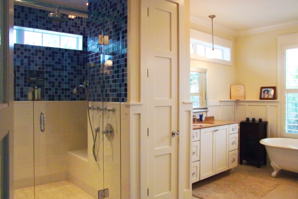 Bild på ett mellanstort maritimt badrum, med ett undermonterad handfat, möbel-liknande, vita skåp, granitbänkskiva, ett badkar med tassar, en hörndusch, blå kakel, keramikplattor, gula väggar och klinkergolv i keramik