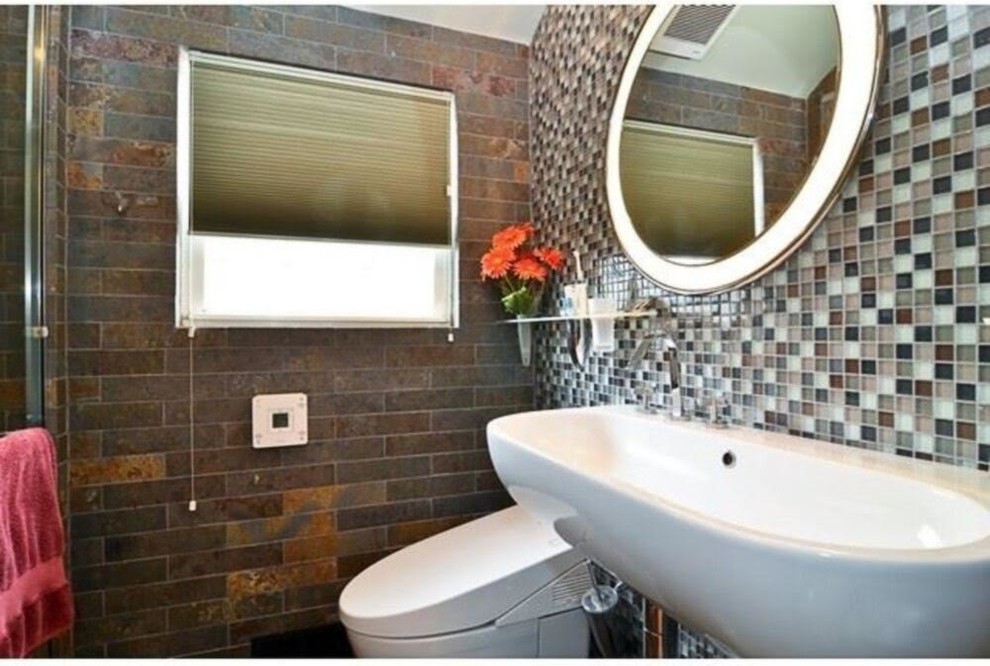 Cette image montre une petite salle de bain design avec WC suspendus, un carrelage en pâte de verre, un mur marron et un lavabo suspendu.
