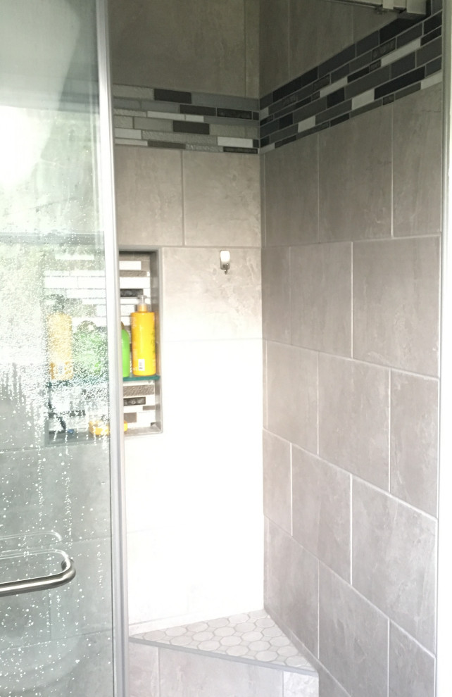 Diseño de cuarto de baño principal pequeño con ducha empotrada, sanitario de dos piezas, baldosas y/o azulejos grises, baldosas y/o azulejos de porcelana y ducha con puerta corredera