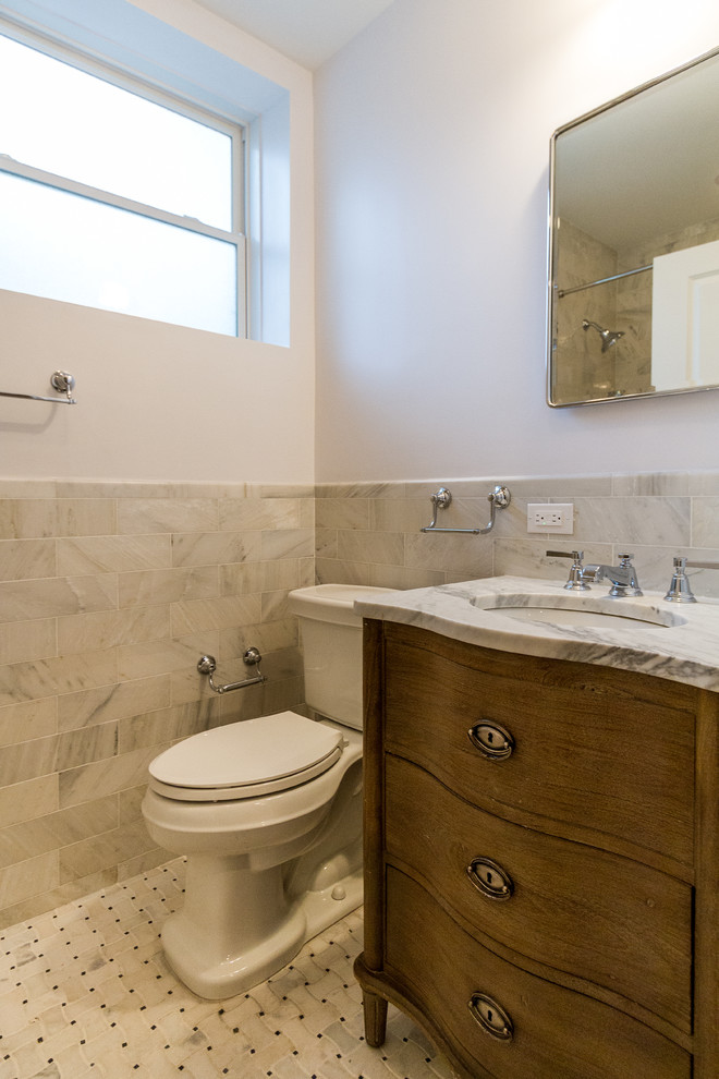 Idéer för mellanstora vintage badrum, med möbel-liknande, skåp i mellenmörkt trä, ett badkar i en alkov, en dusch/badkar-kombination, en toalettstol med separat cisternkåpa, beige kakel, marmorkakel, beige väggar, ett undermonterad handfat, marmorbänkskiva och med dusch som är öppen