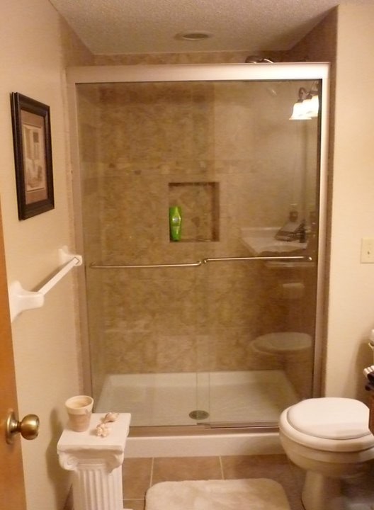 Design ideas for a medium sized classic shower room bathroom in Minneapolis with a built-in sink, flat-panel cabinets, medium wood cabinets, marble worktops, an alcove shower, a two-piece toilet, brown tiles, ceramic tiles, beige walls and porcelain flooring.