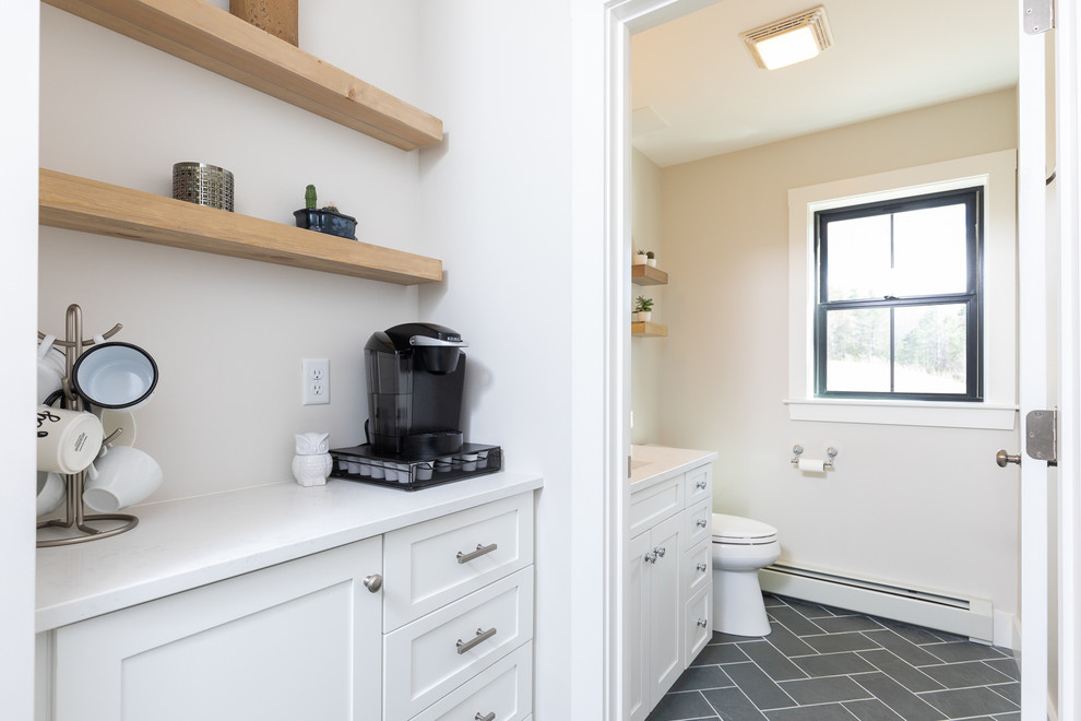 Cette photo montre une petite salle de bain nature avec un placard à porte shaker, des portes de placard blanches, un mur beige, un sol en carrelage de céramique, un lavabo encastré, un sol gris et un plan de toilette blanc.