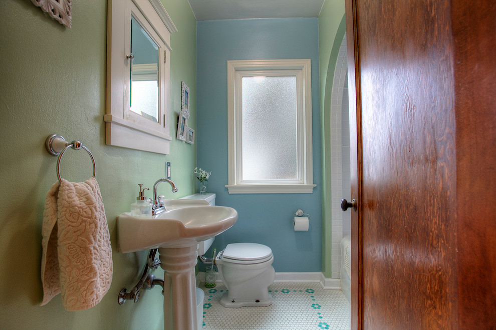 Foto på ett vintage badrum, med ett platsbyggt badkar, en dusch/badkar-kombination, en toalettstol med separat cisternkåpa, vit kakel, blå väggar och cementgolv
