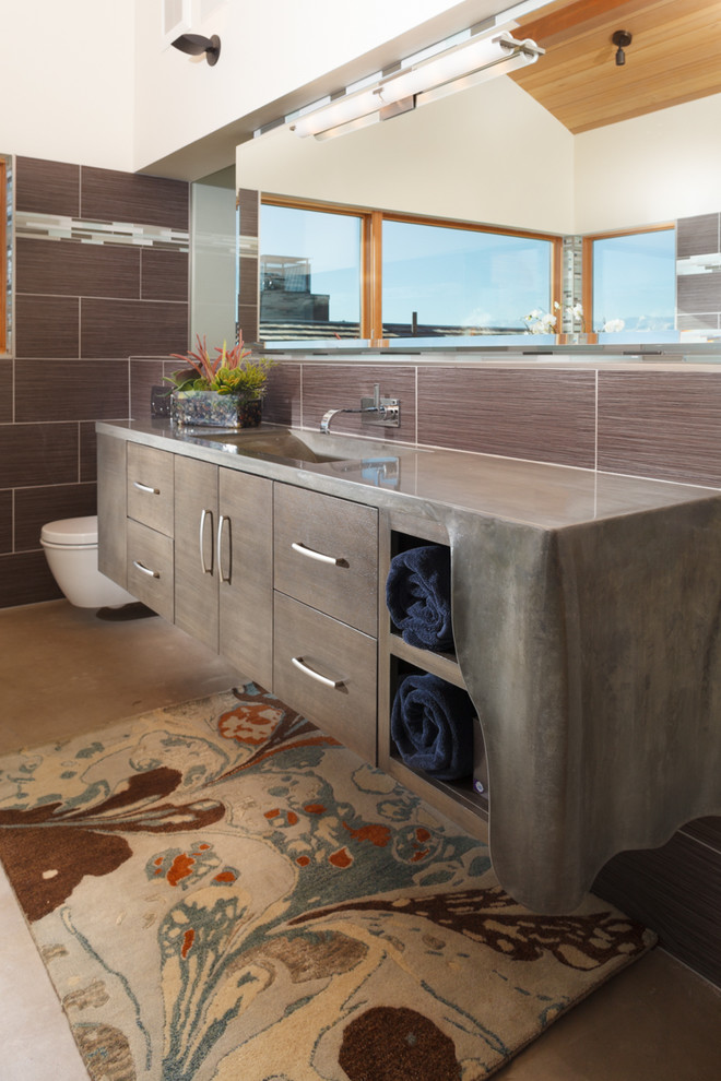 Immagine di una stanza da bagno minimal con ante lisce, ante marroni, piastrelle marroni e WC sospeso